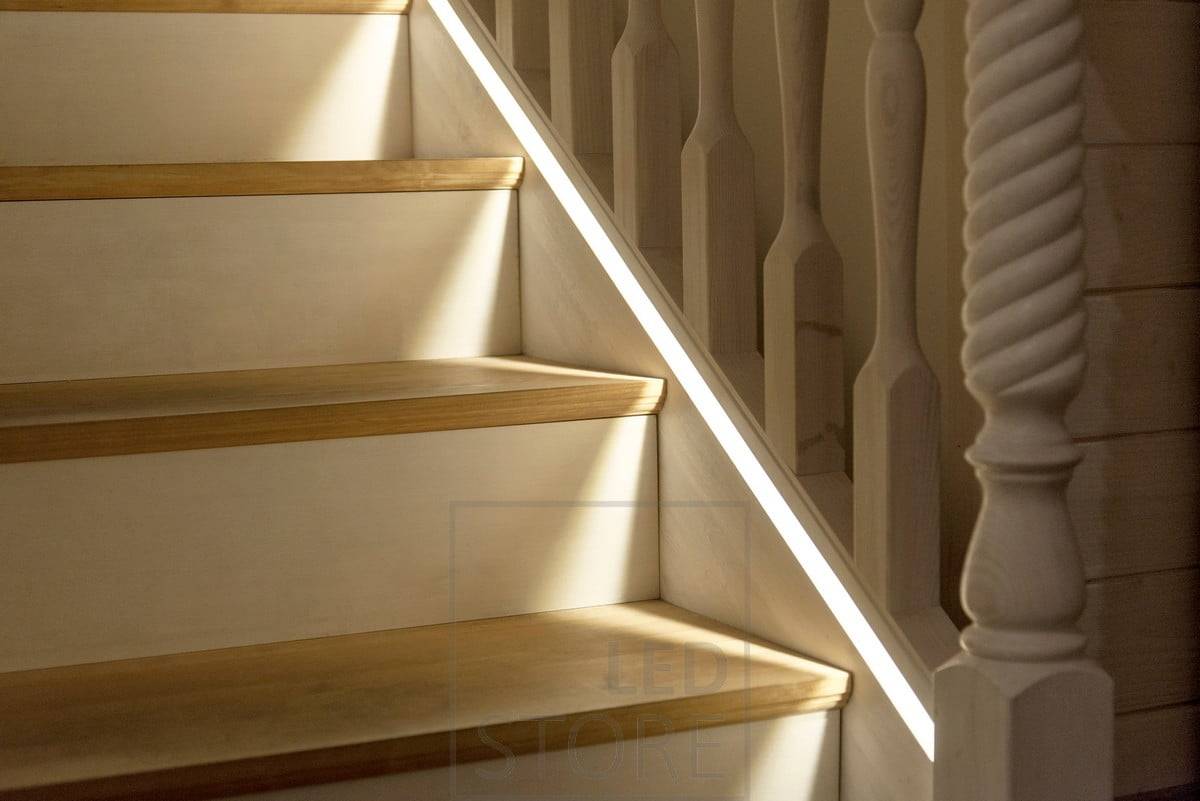 Ruban de leds dans un profil affleurant fraisé dans la rampe d'escalier aussi près que possible des marches.